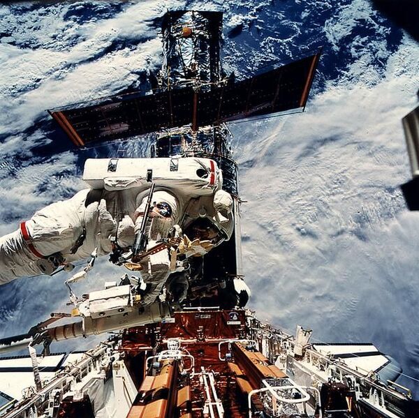رائدة الفضاء التابعة لناسا كاثي ثورنتون تدخل عتاد إصلاح هابل خلال مهمة الخدمة الأولى في 1993. (حقوق الصورة: NASA)