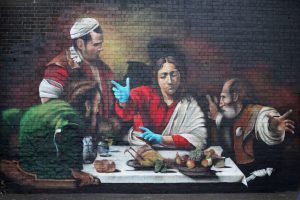 A mural in Ladywell painted by Artist Lionel Stanhope depicting the Supper at Emmaus by Caravaggio with added protective gloves is pictured following the outbreak of the coronavirus disease (COVID-19), London, Britain, May 5, 2020. REUTERS/Hannah McKay NO RESALES. NO ARCHIVES