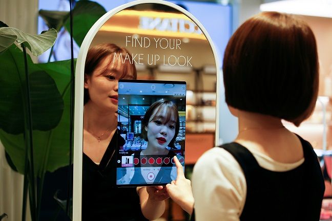 A woman shops using AR make up at a cosmetic shop in a department store in Seoul, South Korea, July 2, 2020. Picture taken July 2, 2020. REUTERS/Heo Ran