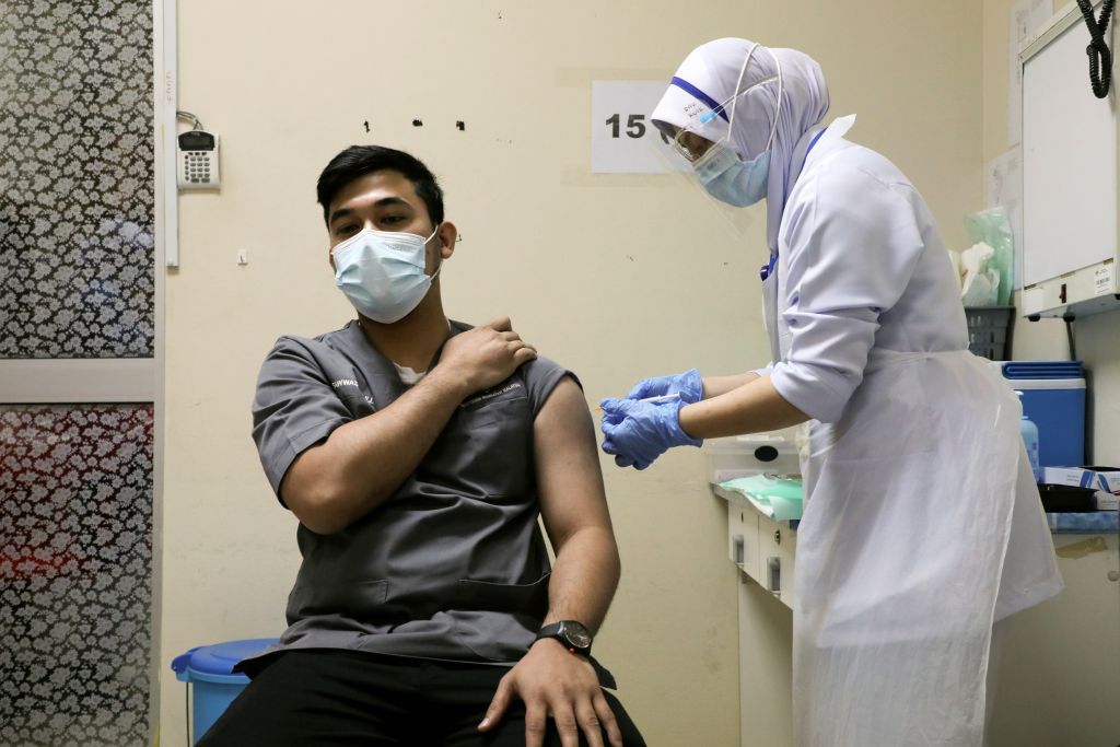 A medical worker receives a vaccine for the coronavirus disease (COVID-19) during a vaccination program at Kuala Lumpur Hospital in Kuala Lumpur, Malaysia March 1, 2021. REUTERS/Lim Huey Teng